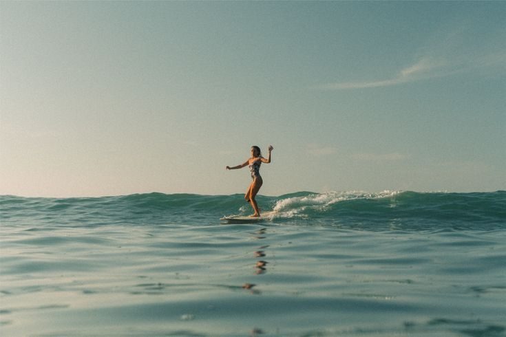 Surfista tomando una ola en La Barrosa, agua salpicando alrededor de la tabla